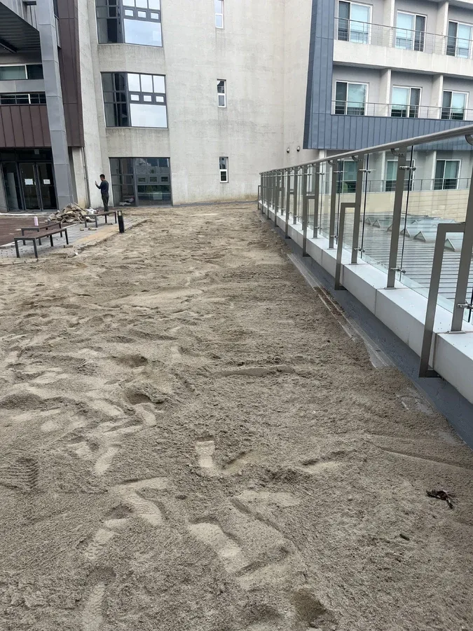 안성 건물 난간 옆 통로 모래가 두껍게 덮인 상태
