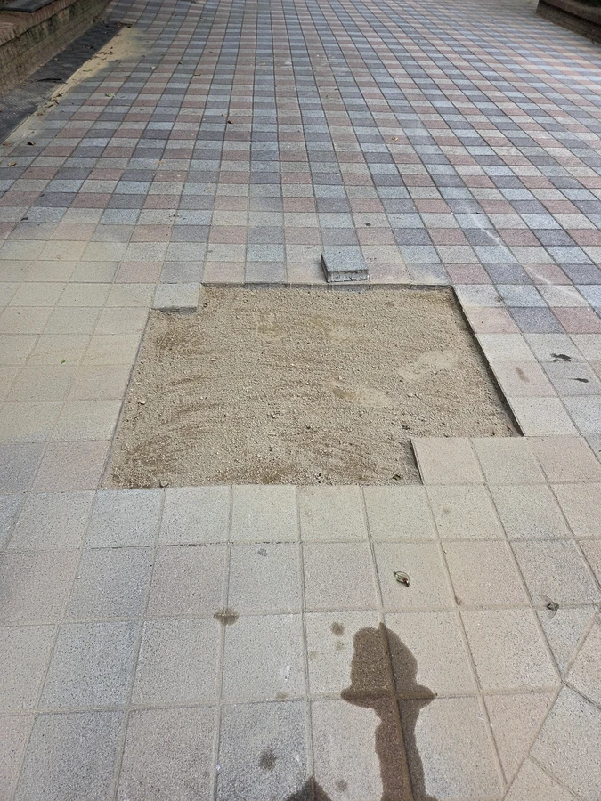 모래 채움으로 정리된 상가 앞 사각블럭 패치